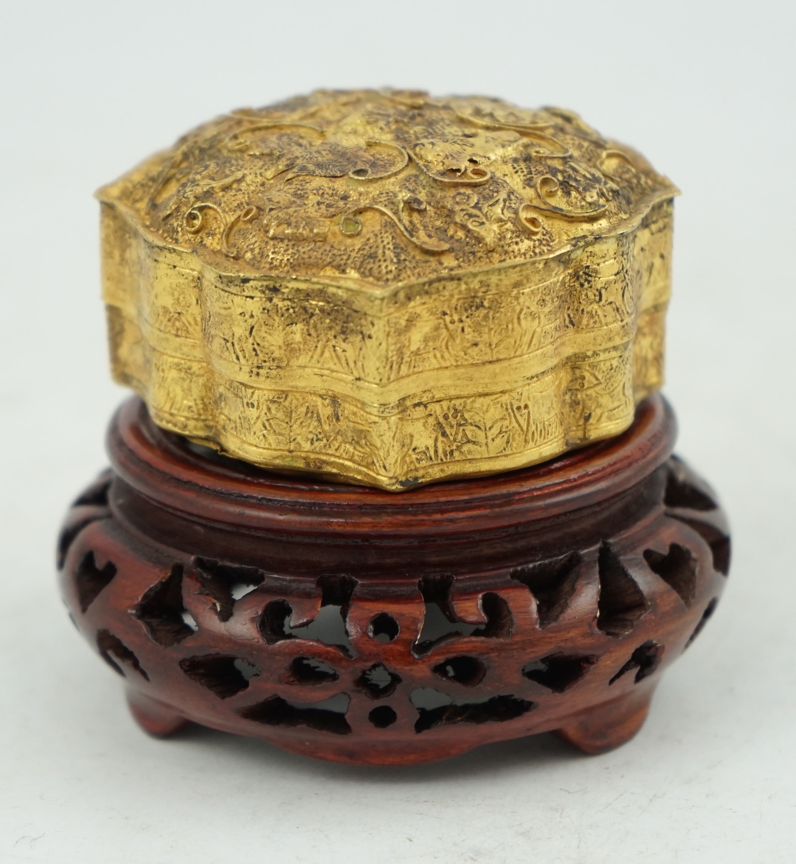 'An 18th century Chinese gilt repousee box & cover, probable Liao Dynasty', of petal lobed form, decorated with lions amid filigree scroll work, 5.5cm across